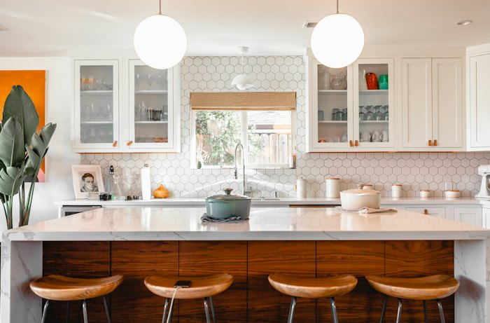 Kitchen with an island, pendant lights and built-in appliances.