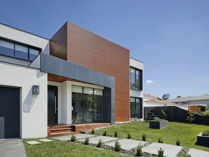 Modern house facade with large aluminium-framed windows.